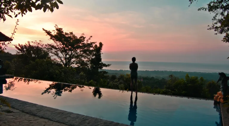 Guest at the edge of an infinity pool at dusk