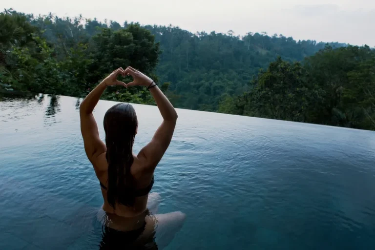 Guest in a jungle-view infinity pool