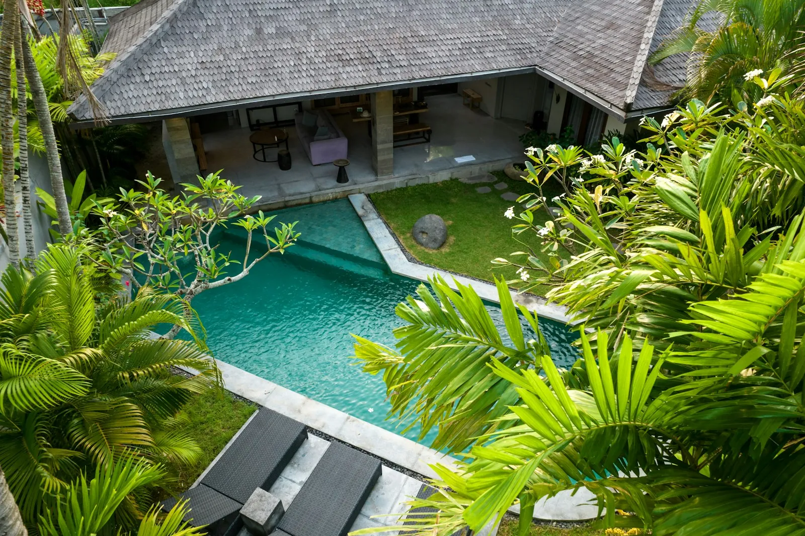 Tropical villa pool framed by palms, seen from above