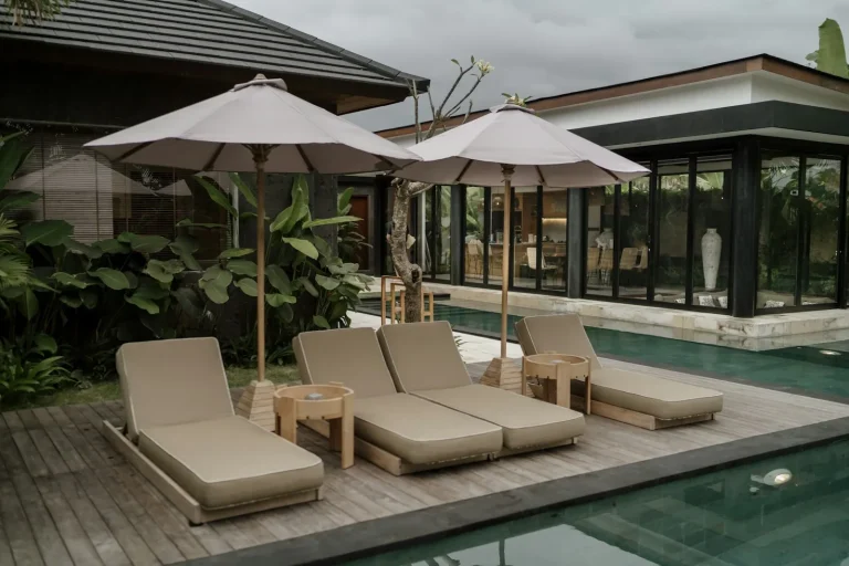 Private villa pool deck with sun loungers and umbrellas